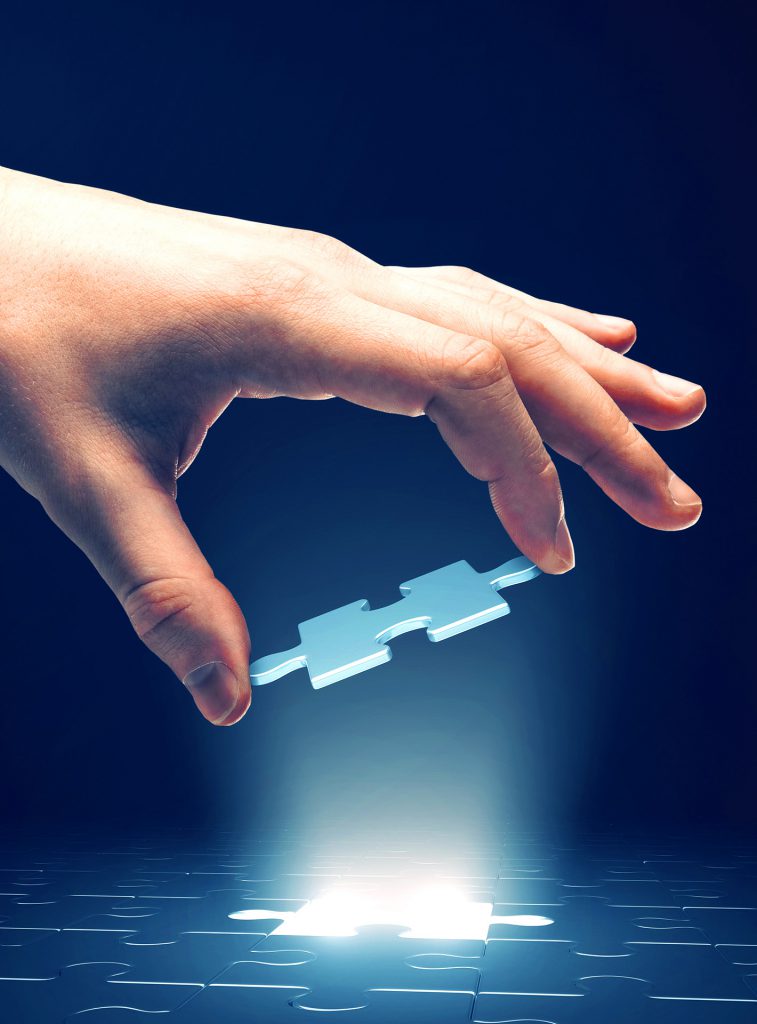 Business mans hand placing the final puzzle piece to complete a tech transition